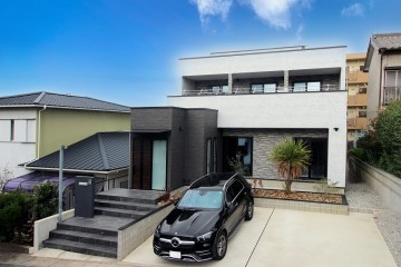モルタル調のシックな外観を持ち、インテリアでは、珪藻土の塗り壁と木板貼りの堀込天井がおしゃれなLDKのある高級住宅