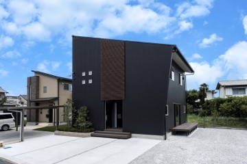 ブラックのガルバリウム鋼板と木目調ルーバーが際立つシンプルモダンなファサードをもつデザインハウス（静岡県浜松市）